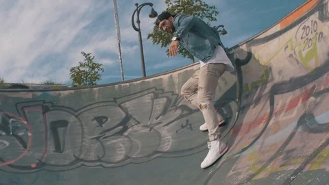Skater guy sliding down a half pipe Stock Footage 87261538