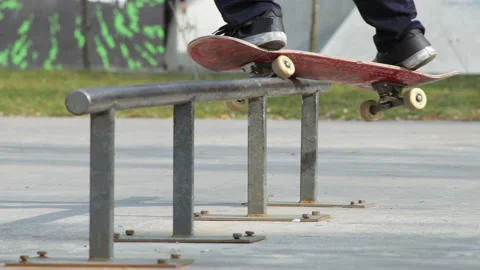 Skater make grind trick feeble on rail in skatepark, close-up view in slowmotion Stock Footage 96127422