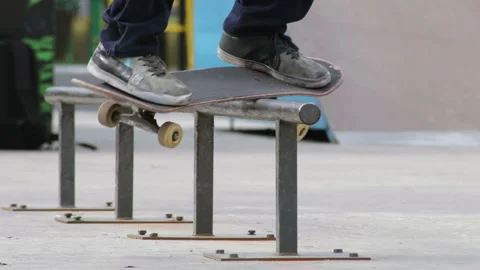 Skater make grind trick feeble on rail in skatepark, close-up view in slowmotion Stock Footage 96127680