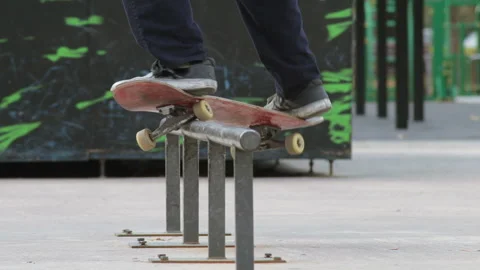 Skater make grind trick smith on rail in skatepark, close-up view in slowmotion Stock Footage 96128995