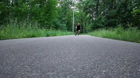 Skater moves fast on roller skates along a path in a green area Stock Footage 341817088