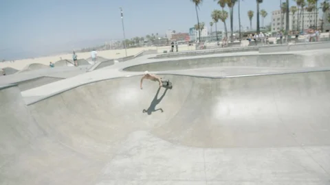 SKATER PERFORMS TRICK ON VENICE BEACH SKATE PARK IN SLOW MOTION Stock Footage 127470762