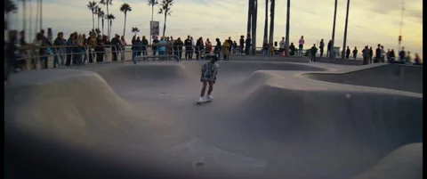 Skater Preparing to Drop Into Venice Beach Skate Park at Sunset – Cinematic Back Stock Footage 322137034