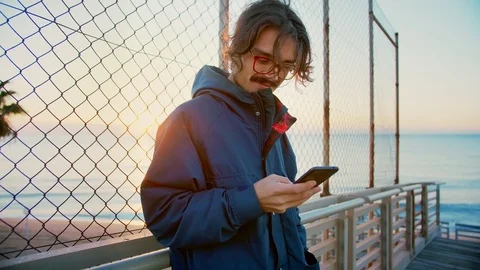 Skater using smartphone app checking internet social network news be up to date Stock Footage 100861585