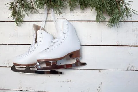 Skates and pine branches on a background of white wood Stock Photos