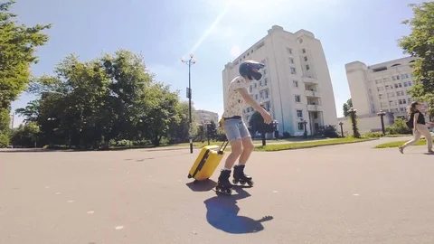 Skating with yellow luggage and then stops Stock Footage 114382053