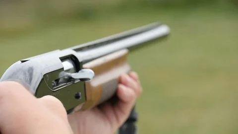 Skeet shooting shotgun aiming and shooting somewhere in autumn in slow motion Stock Footage