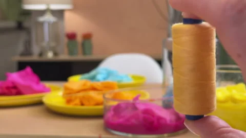 A skein of colored thread spinning in the hand in close-up against the backgroun 库存影片 306212149