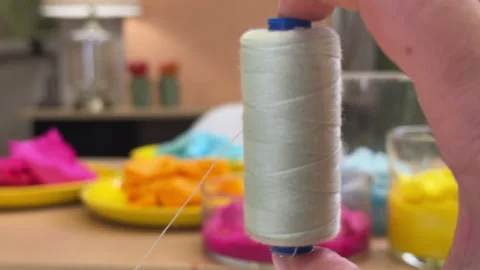 A skein of colored thread spinning in the hand in close-up against the backgroun Stock-Footage 306212175