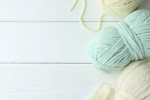Skeins of yarn and pattern sample on white wooden table, flat lay. Space fo.. Foto stock
