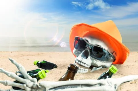Skeleton of a celebrating person died of too much alcohol on a beach Stock Photos