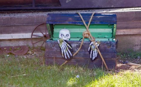 Skeleton crawling out of a trunk Stock Photos