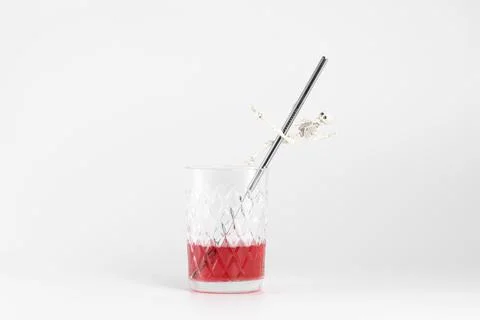 A skeleton dances a striptease on a metal straw in a glass of juice Stock Photos