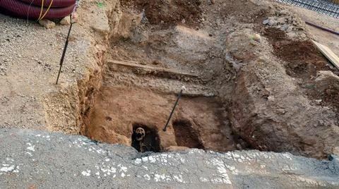 Skeleton discovered during construction work in a digging site near a road Stock Photos