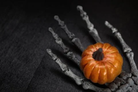 Skeleton hand holding pumpkin Stock Photos