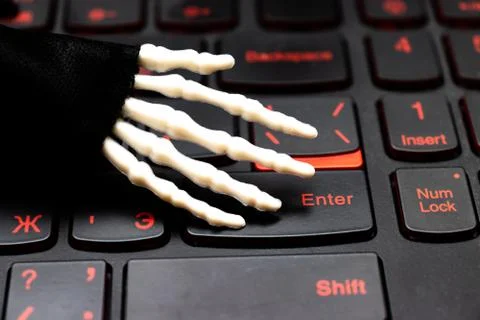 Skeleton hand ready to work on computer, laptop gaming keyboard Stock Photos