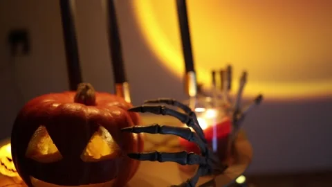 Skeleton hands and candles create a frightening Halloween decoration at night Video stock 346147588