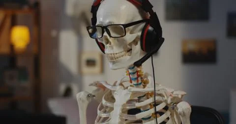 Skeleton with headphone sitting at computer Stock Photos