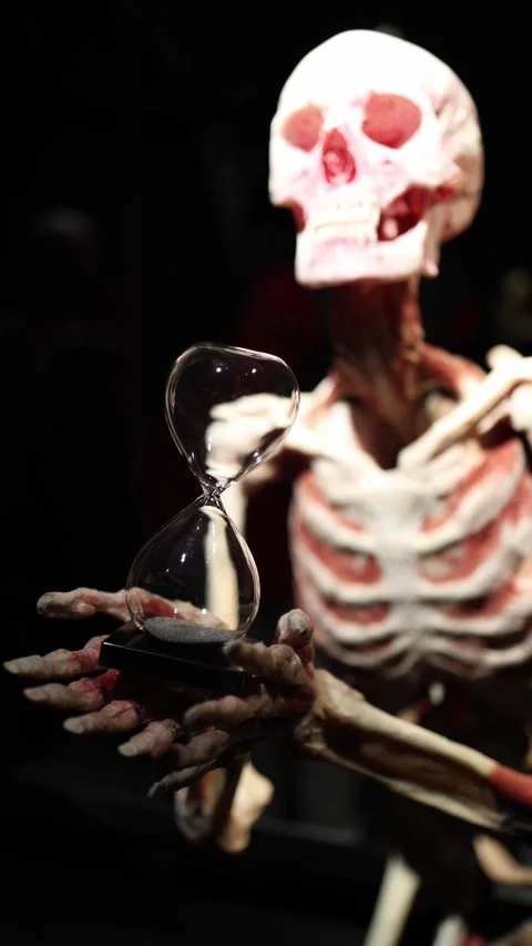 Skeleton with hourglass symbolizing time and mortality Video stock 331233108