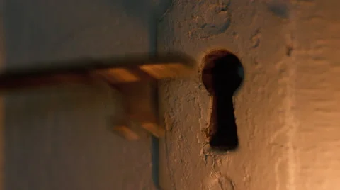 Skeleton key inserted in door by candlelight Stock Footage 63057315