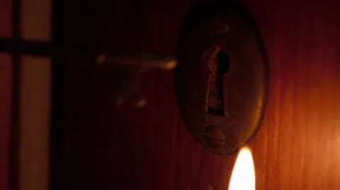 Skeleton key inserted in door by candlelight Stock Footage 63058560
