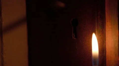 Skeleton key inserted in door by candlelight Stock Footage 63074838