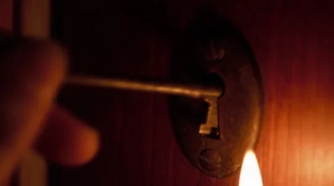 Skeleton key inserted in door by candlelight Stock Footage 63074950