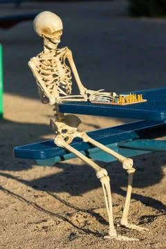 Skeleton making his move in chess Foto stock