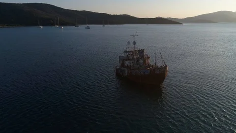The skeleton of a merchant ship stranded in bay against the mountains. Aerial 스톡 동영상 98225061