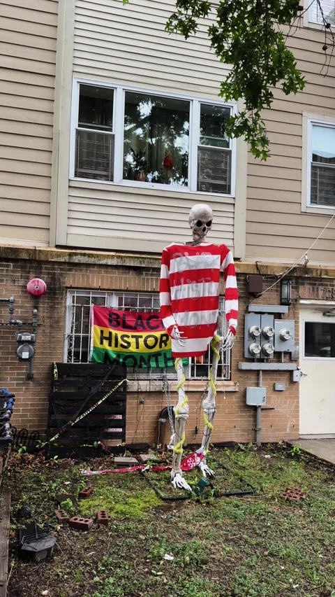Skeleton in Striped Shirt in Front Yard of Brooklyn Apartment Building with Stock Footage 338103800