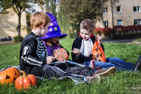 Skeleton, witch and vampire sharing Halloween candies. Outdoor portrait Foto stock