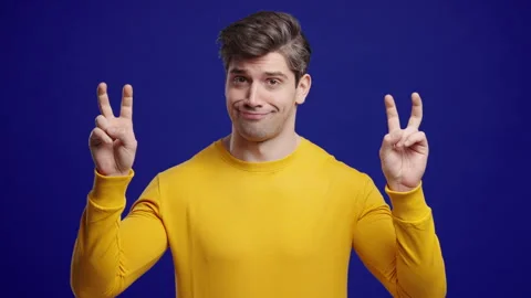 Skeptic Young Man With Hands Two Fingers Air Quotes On Blue, Sarcasm,Cynicism Stock Footage 319964450