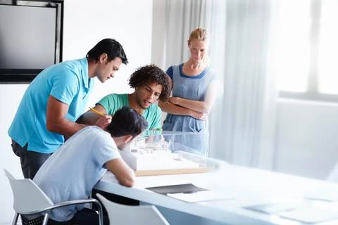Skeptical about the structure. A group of architects discussing a building model Fotos de archivo