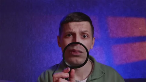 Skeptical man looking at camera with enlarged mouth through lens Stock Footage 333757089