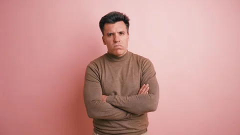 Skeptical middle aged man showing disapproval on a pink background Stock Footage 339039507