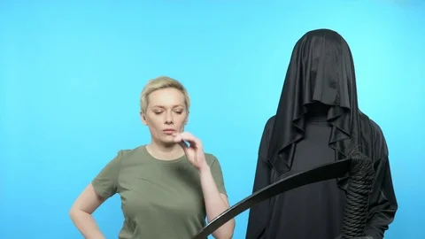 Sketch on a blue background death stands next to a woman who lights a cigarette Stock Footage 125899347