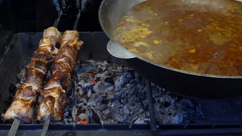 Skewer on a spit rotates on the grill next to the boiler in 4K Stock Footage 123283231