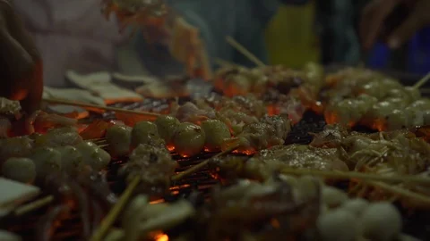Skewers of meat cooked on the grill while people cooking and dancing Stock Footage 111014863