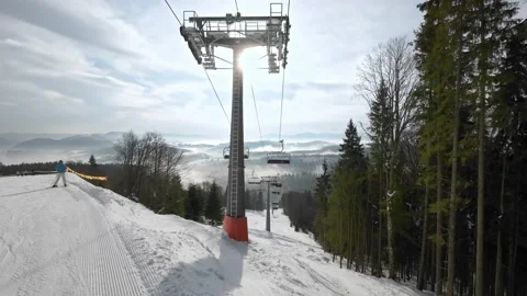 Ski elevator with people in the background of the beautiful mountain scenery. Stock Footage 219004018