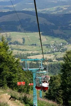 Ski elevator with red chairs moving down. Carpathians Gimba Mountain. Stock Photos
