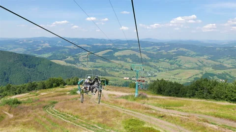 Ski elevator  rope up to mountain with two  man’s cyclist. 4K 3 Stock-Footage 53466970