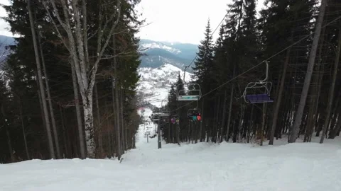 A ski elevator takes people up the mountain at a ski resort. Stock Footage 219004405