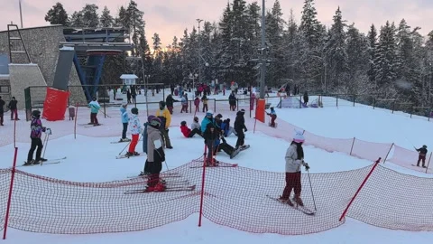 Ski enthusiasts are honing their skills on a picturesque snowy hill at a bustlin Stock Footage 344951380