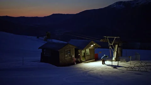 Ski field worker at T Bar lift in pre dawn snowfield Stock Footage 159692983