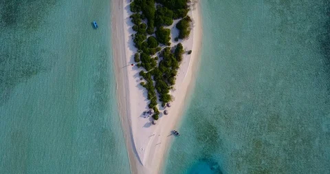 Ski jet tracking around oval shape of exotic island surrounded by coral Stock Footage 119194800