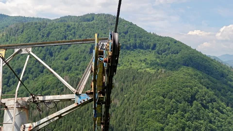 Ski lift pulley tower with cable and green mountain background Stock Footage 337551711