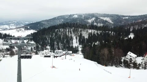 Ski lift with seats going over the mountain and paths from skies and snowboar Stock Footage 121372844