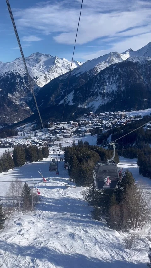 Ski lifts in ski resort by winter over the snowy slopes of Courchevel town Stock Footage 334414101
