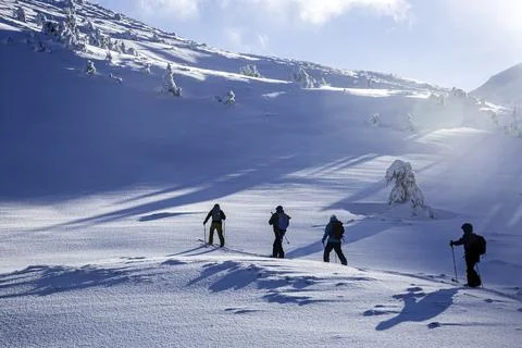 Ski mountaineers push through the pristine snow of the mountains, aiming fo.. Stock Photos