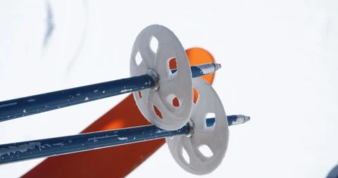 Ski pole baskets with orange skis on chair lift Stock Footage 95372957
